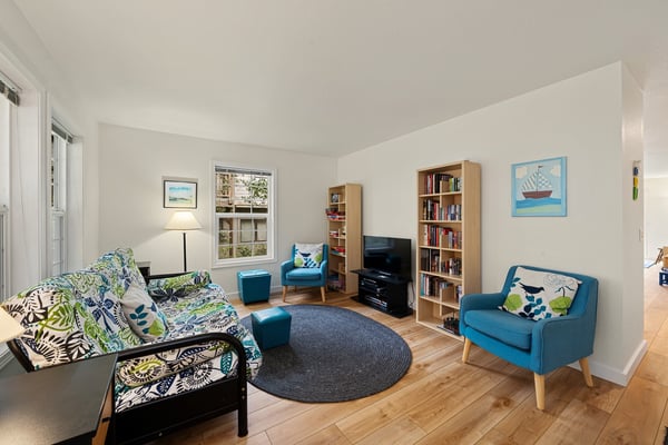 Settle into this bright, cheerful living space with plush seating, books for every mood, and cheerful pops of blue and green inviting you to unwind completely.