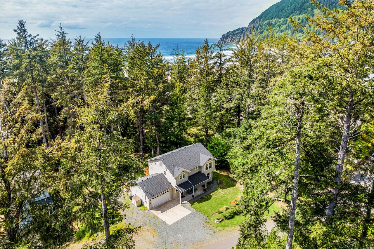 Charming coastal retreat nestled among evergreens with mountain and ocean views, offering peaceful privacy near the beach.