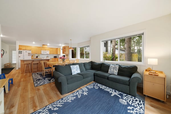 Picture yourself unwinding on the plush sectional, natural light pouring through large windows, and the open kitchen inviting you to whip up meals with ease.