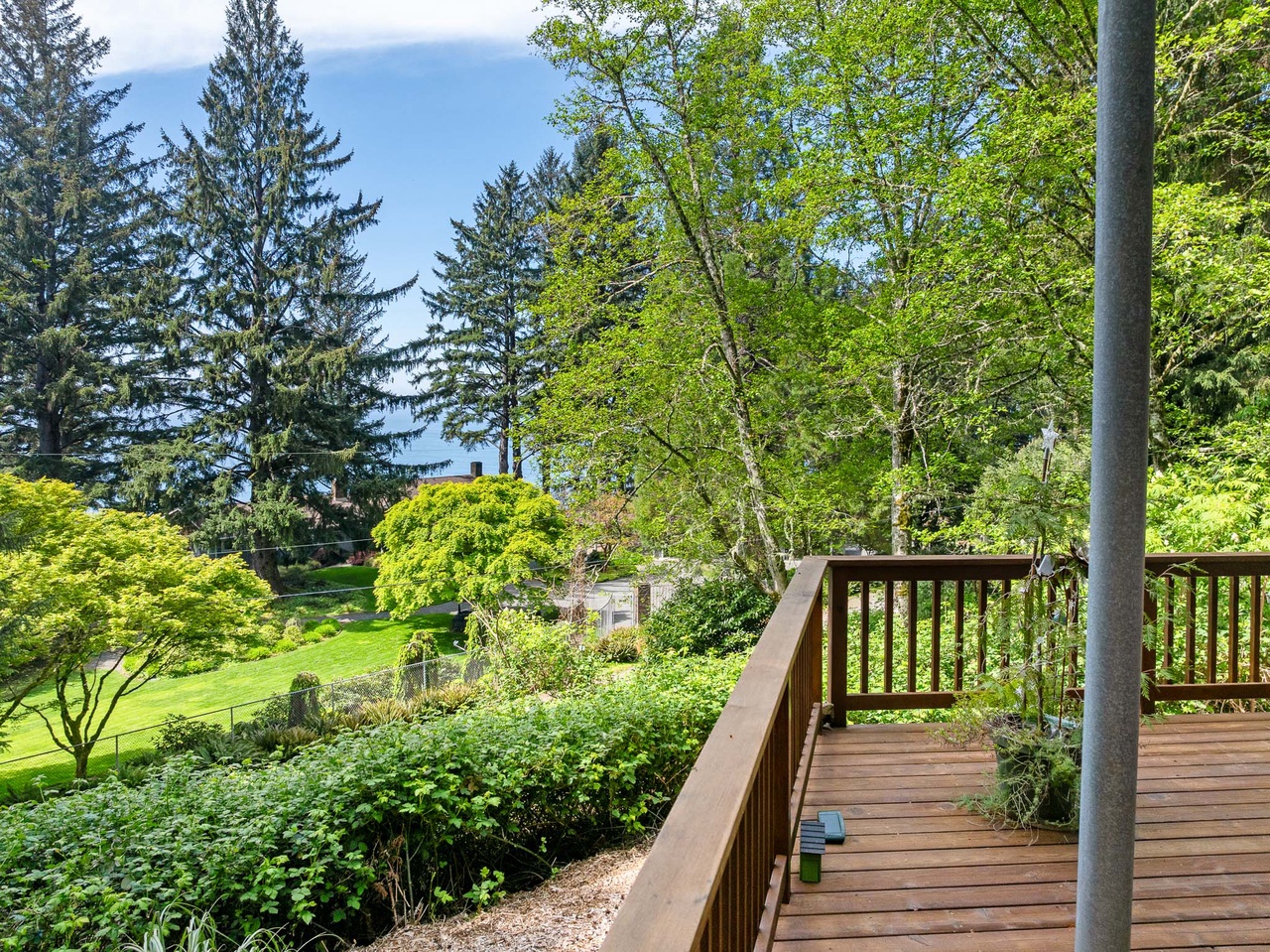 This property is nestled among lush evergreens and leafy trees, set in a peaceful neighborhood with expansive green lawns and abundant natural surroundings.