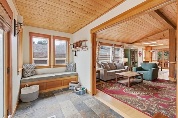 Unwind in this inviting living space where warm wood beams frame your perfect retreat, complete with cozy window seating and comfortable furnishings.